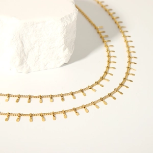 Detailed close-up of 18K gold stainless steel choker featuring rectangular fringe charms