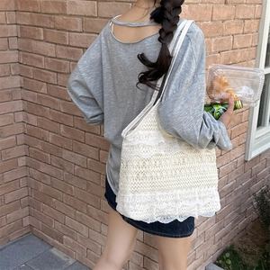 Détail du sac cabas en dentelle blanche multicouche avec texture ondulée et motifs résille