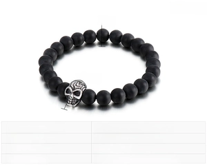 Macro shot of 8mm black matte agate beads and stainless steel skull pendant