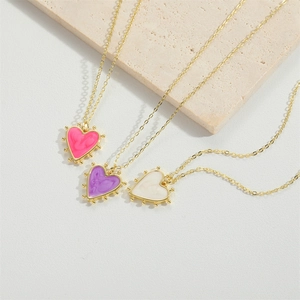 Three gold heart enamel pendant necklaces in pink, purple, and white minimalist styles