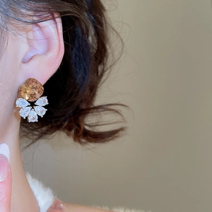 Detail showing elegant champagne square zircon earrings worn on a model in a close-up side view