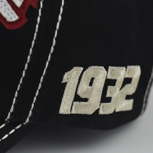 Black cotton baseball cap featuring 1932 side embroidery and white decorative stitching