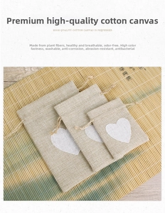 Three sizes of linen drawstring gift bags with white heart print on bamboo mat background