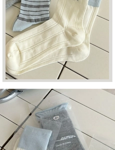 Detail of cream white ribbed crew socks with brand packaging and embroidery
