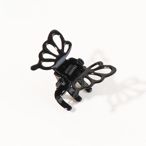 Detail of a mini butterfly hair claw clip in glossy black finish with hollow wing design