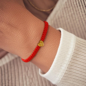 Red braided nylon rope bracelet featuring a gold heart charm with letter A engraving