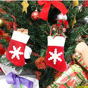 Felt Christmas stocking decorations with snowflake patterns on a festive tree branch