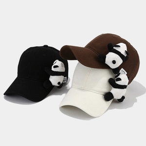 Detailed view of baseball caps in black, brown, and white with 3D panda plush decoration