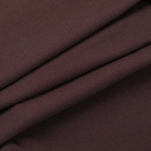 Gros plan sur la texture du tricot marron foncé montrant un drapé souple et des détails