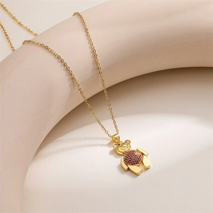 Vue détaillée d'un collier pendentif ours doré orné de pierres de zircon rouges