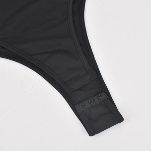 Detailed macro view of the three-button snap crotch closure on a black elastic bodysuit