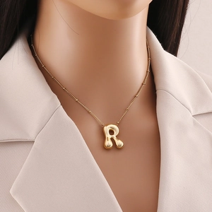 Dettaglio della collana con pendente a lettera R effetto bolla placcata oro 18K