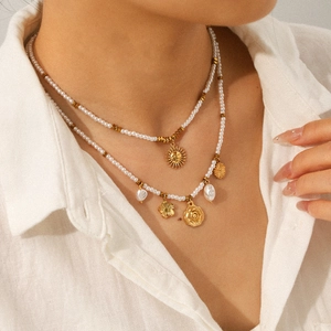 Layered gold necklace with sunflower, portrait coin and baroque pearl charms for women