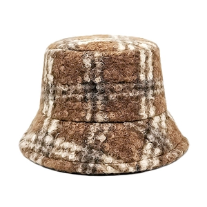 Detail of winter thick plush bucket hat with brown and white checkered wool texture