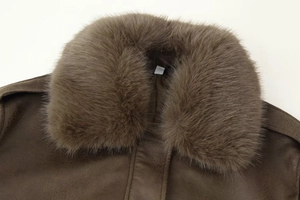 Detail of a brown suede jacket featuring a thick faux fur collar and premium texture
