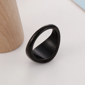 Macro shot of minimalist wide black band ring with brushed inner texture on white surface