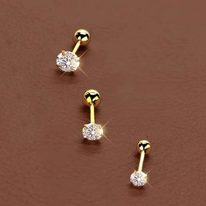 Detailed view of three gold stainless steel ball-back studs with sparkling white zircons