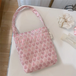Detail of pink floral heart jacquard fabric on a small tote bag with a simple wish tag