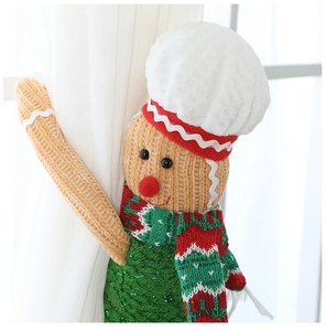 Close-up of knitted gingerbread man curtain tieback with festive red and green scarf