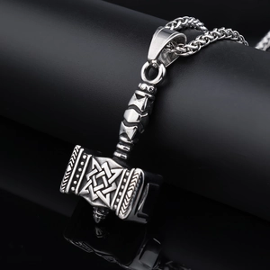 Detailed close-up of a silver Mjolnir pendant with intricate Norse knot textures