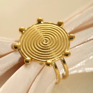 Macro detail of a 18k gold plated stainless steel ring with spiral textured design
