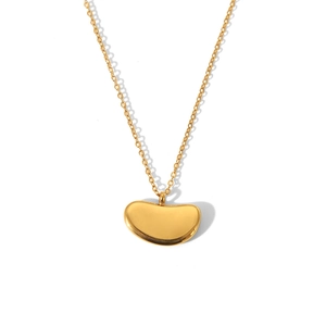 Detailed view of a polished gold bean-shaped pendant on a minimalist stainless steel chain