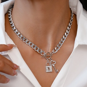 Close-up of silver OT buckle necklace with rhinestone-encrusted lock and key pendants