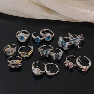 Adjustable silver butterfly ring set with blue zircon and enamel on black surface