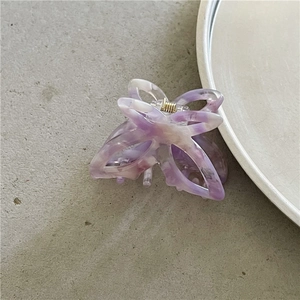 Detail view of small marbleized purple butterfly hair claw clip with golden spring hinge