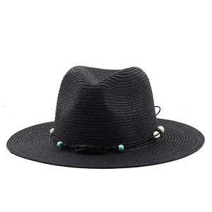 Détail du chapeau Panama noir tissé avec perles turquoise et décoration de coquillages