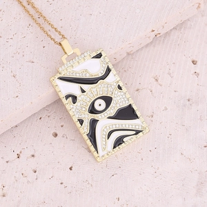 Close-up of golden rectangular Virgin Mary pendant with enamel eye pattern and crystals