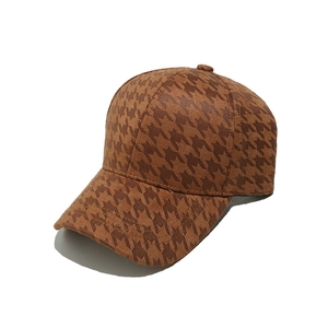 Close-up of brown houndstooth pattern and suede texture on a six-panel baseball cap