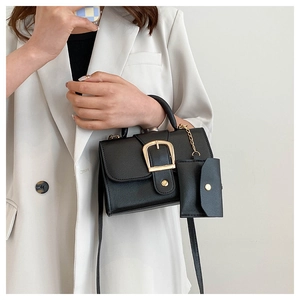 Detail of black litchi pattern leather bag with gold square buckle and mini coin pouch
