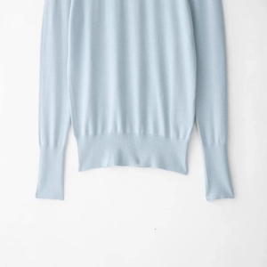 Light blue knit sweater with long sleeves featuring ribbed cuffs and hem in a minimalist style