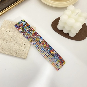 Minimalist wide tooth acetate hair comb with a colorful tortoiseshell pattern and glossy finish