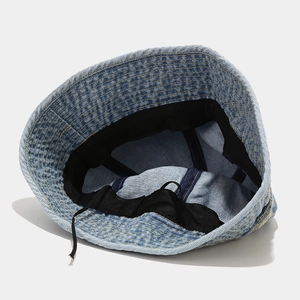 Detailed interior of a blue denim bucket hat showing adjustable drawstring and sweatband