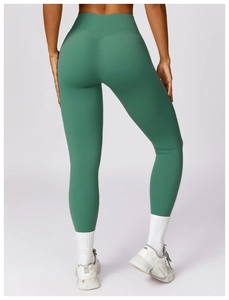 Detail of high-waisted dark green yoga pants with V-shaped waistband and sculpting seam