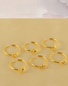 Detail of adjustable 18k gold plated stainless steel rings with crown and heart charms