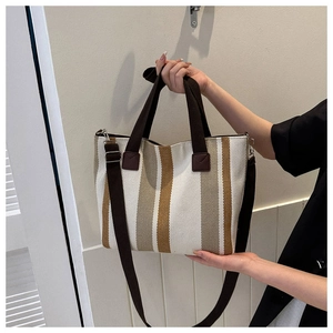 Detail of canvas tote bag with vertical brown and yellow stripes and adjustable shoulder strap