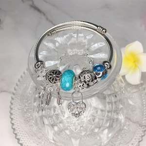 Dettaglio del braccialetto d'argento con perline blu, acchiappasogni e ciondoli a cuore