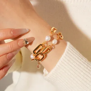 Double-layered gold chain bracelet with white freshwater pearls worn on a wrist