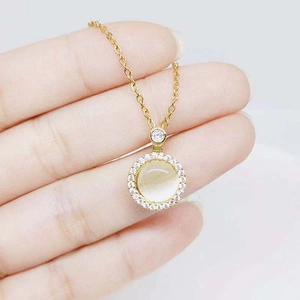Detail of rotating cat eye stone pendant necklace with zircon inlay on hand model