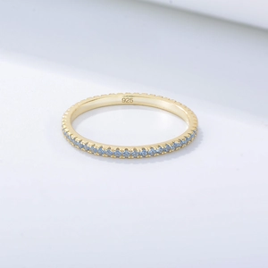 Close-up of S925 sterling silver gold ring featuring a row of blue zircon gemstones
