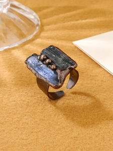 Detailed macro shot of vintage bronze double-headed ring with raw blue gemstones