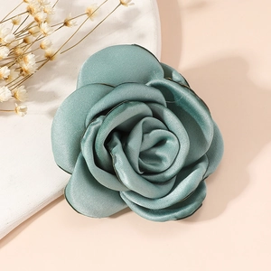 Detailed view of handmade teal fabric rose brooch with elegant silk-like satin petals