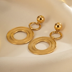 Polished gold-plated titanium steel oversized layered hoop earrings on silk background