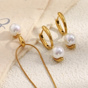 Macro view of 18K gold-plated snake chain necklace and pearl huggie hoop earrings