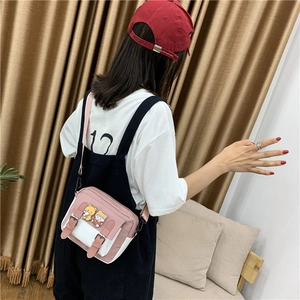 Detail of pink and white nylon crossbody bag featuring cute cartoon bear decorations