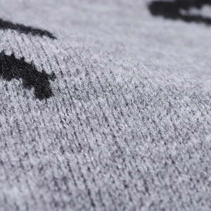 Gros plan d'un bonnet en maille jacquard gris et noir à texture douce épaisse
