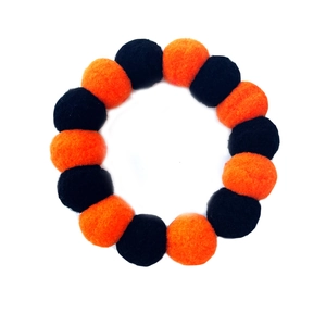 Detail of Halloween pet collar with fluffy orange and black pom-poms for cats and dogs